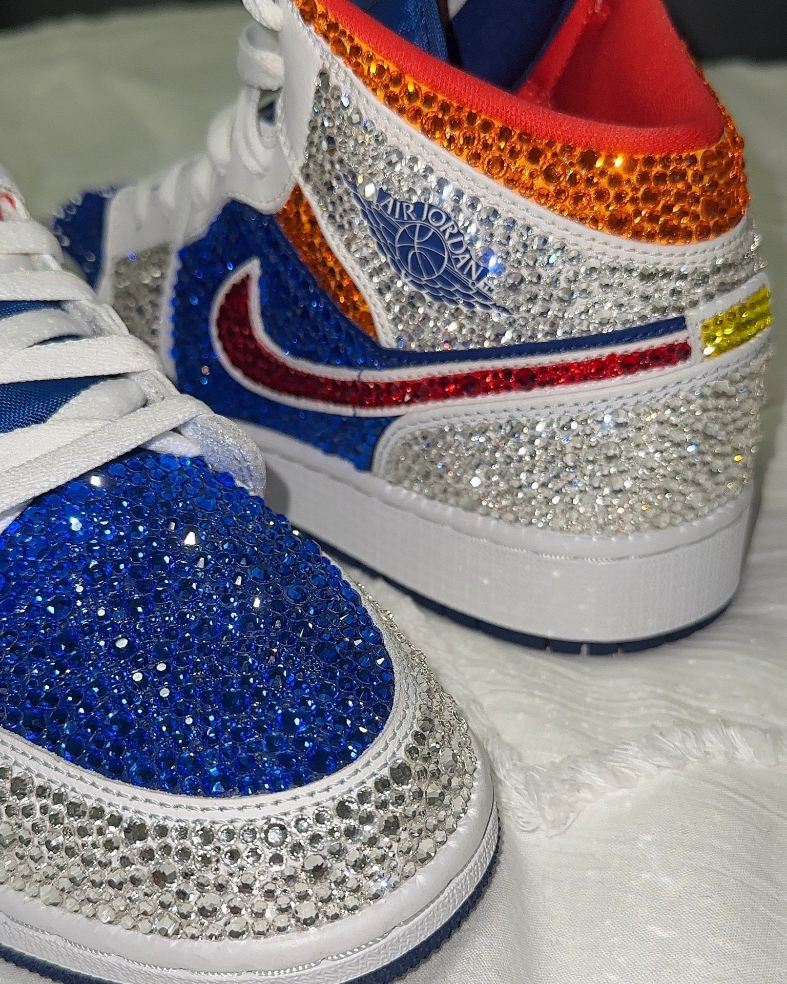 Nike sneakers with colorful rhinestone embellishments on a white background