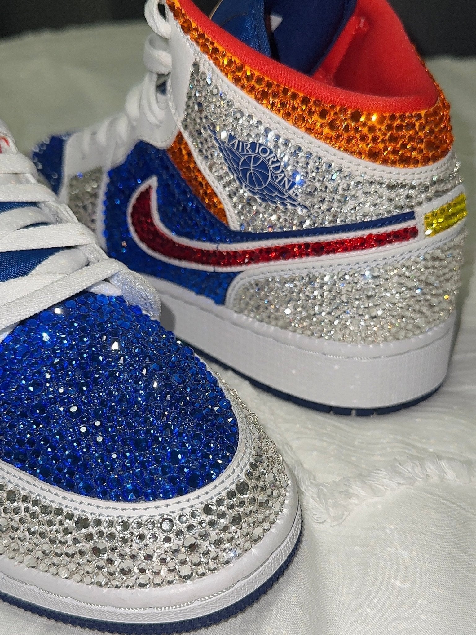 Nike sneakers with colorful rhinestone embellishments on a white background